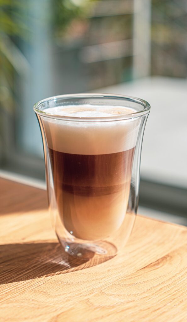 a glass of Spanish latte, its milk, coffee and foam in separate layers.
