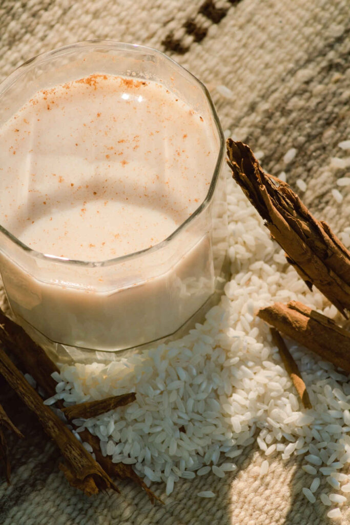 A glass of rice milk with a dusting of cinnamon powder.