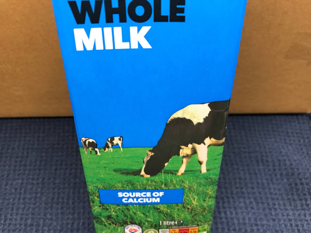 A close up on a carton of whole cows milk