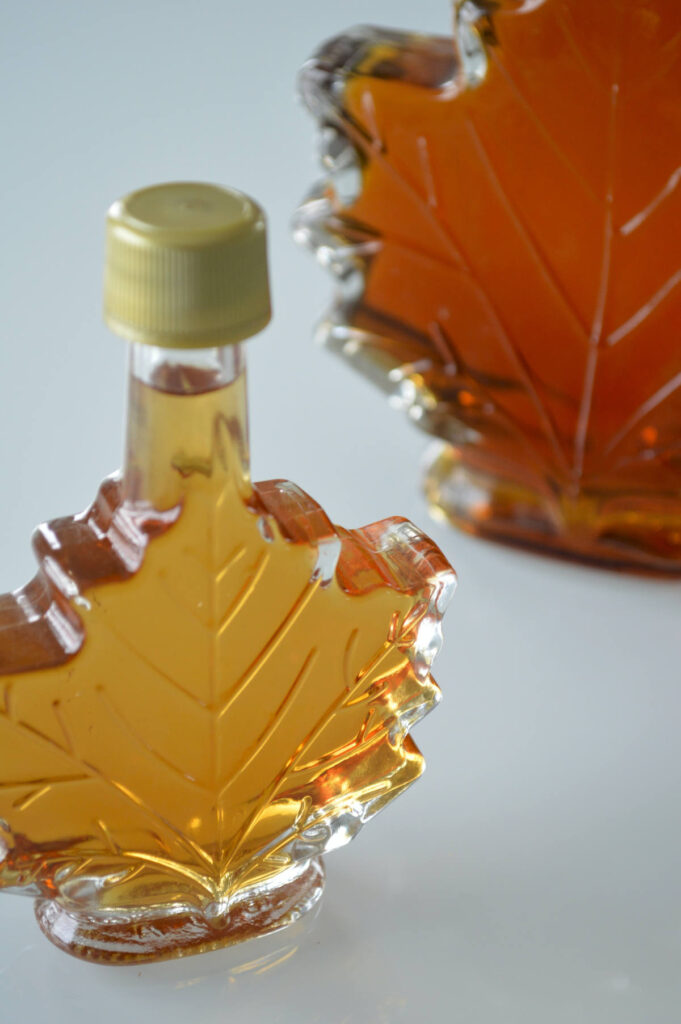 Maple syrup in a bottle shaped like a maple leaf.
