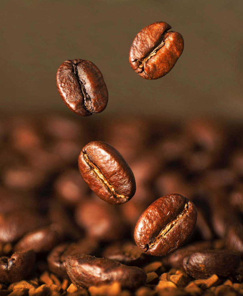 coffee beans tumbling onto a surface.
