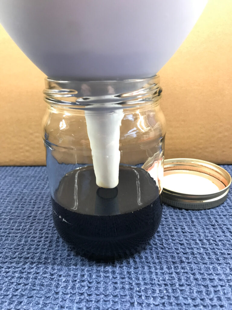 Ccoffee being filtered into a mason jar.