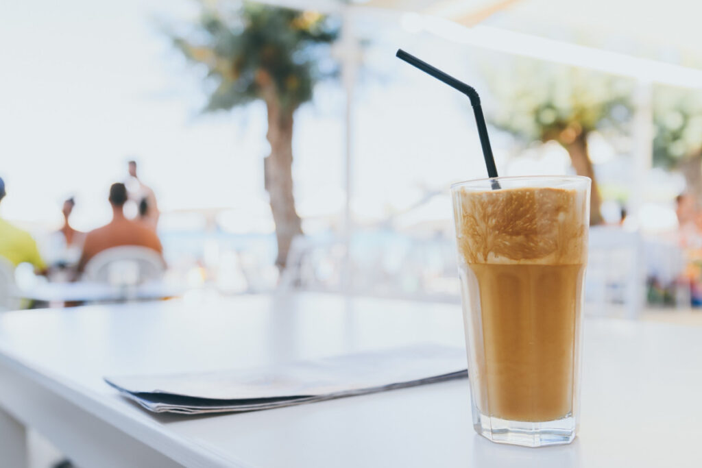 A tall glass of frozen coffee standing on a white table.