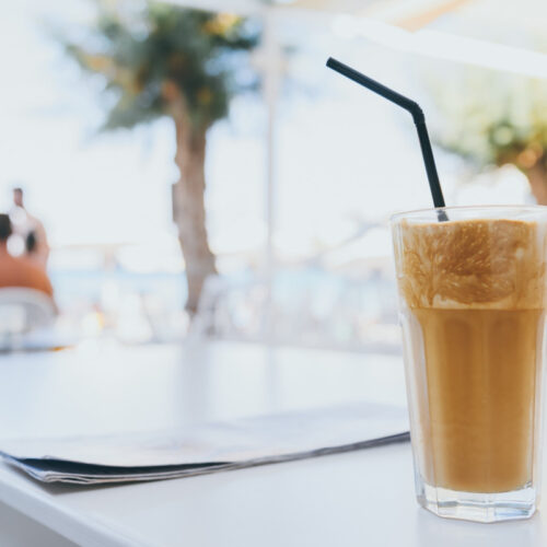 A tall glass of frozen coffee standing on a white table.
