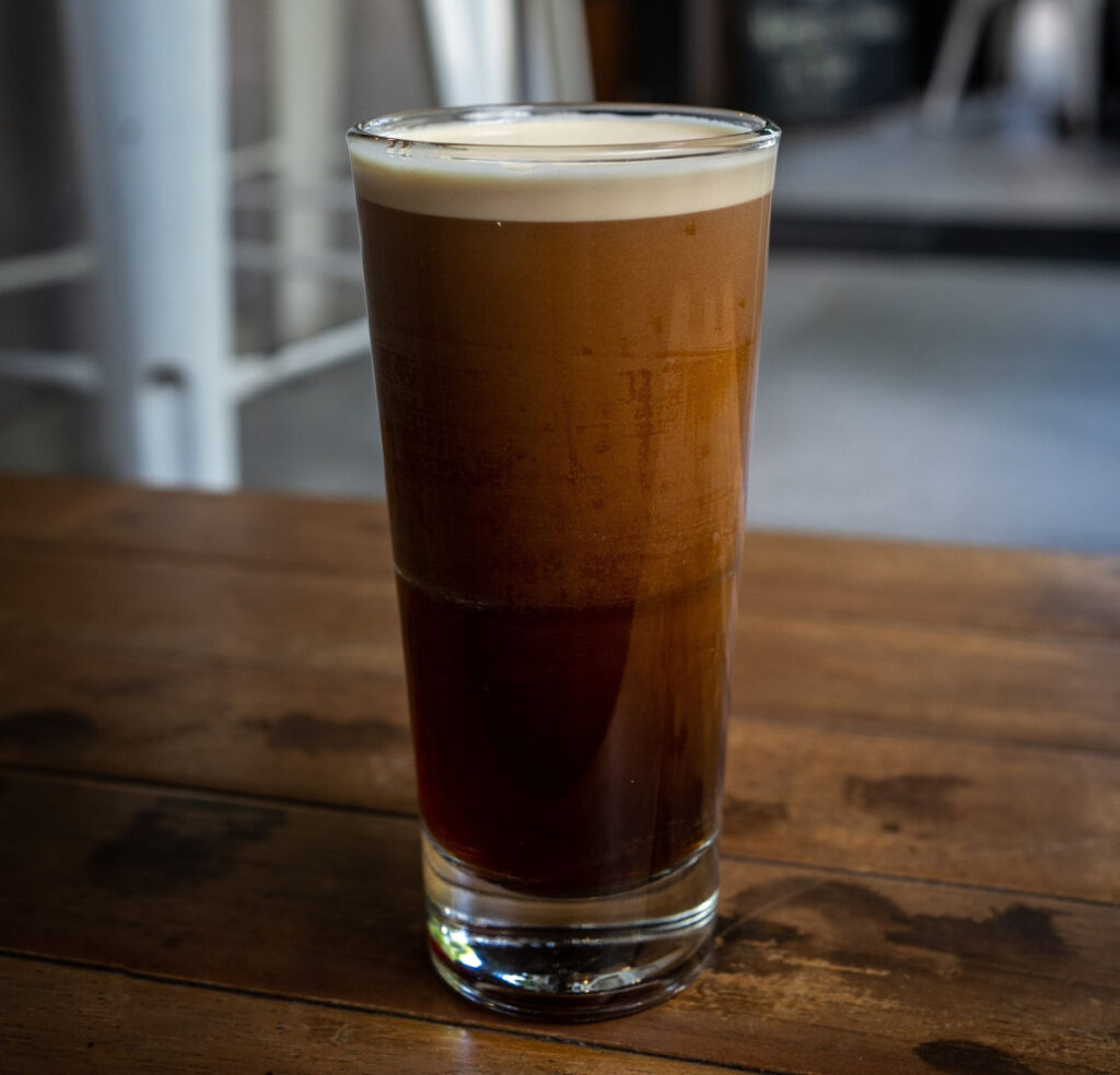 A tall glass of nitro cold brew coffee, gently settling.
